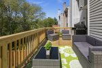 Expansive deck features a cushioned sofa & multiple lounge chairs